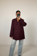 Femme portant le blazer croisé oversize bordeaux, épaules structurées et revers crantés