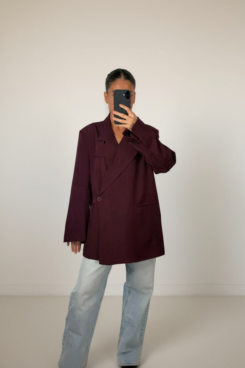 Femme portant le blazer croisé oversize bordeaux, épaules structurées et revers crantés