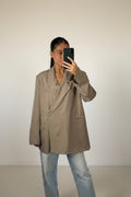 Femme portant le blazer croisé oversize taupe, épaules structurées et revers crantés