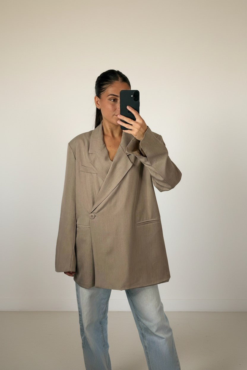 Femme portant le blazer croisé oversize taupe, épaules structurées et revers crantés