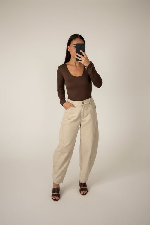 Femme portant le pantalon ballon surpiqué crème, taille haute et jambe arrondie