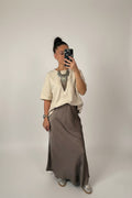 Femme portant la jupe longue satinée taupe avec un t-shirt écru ample