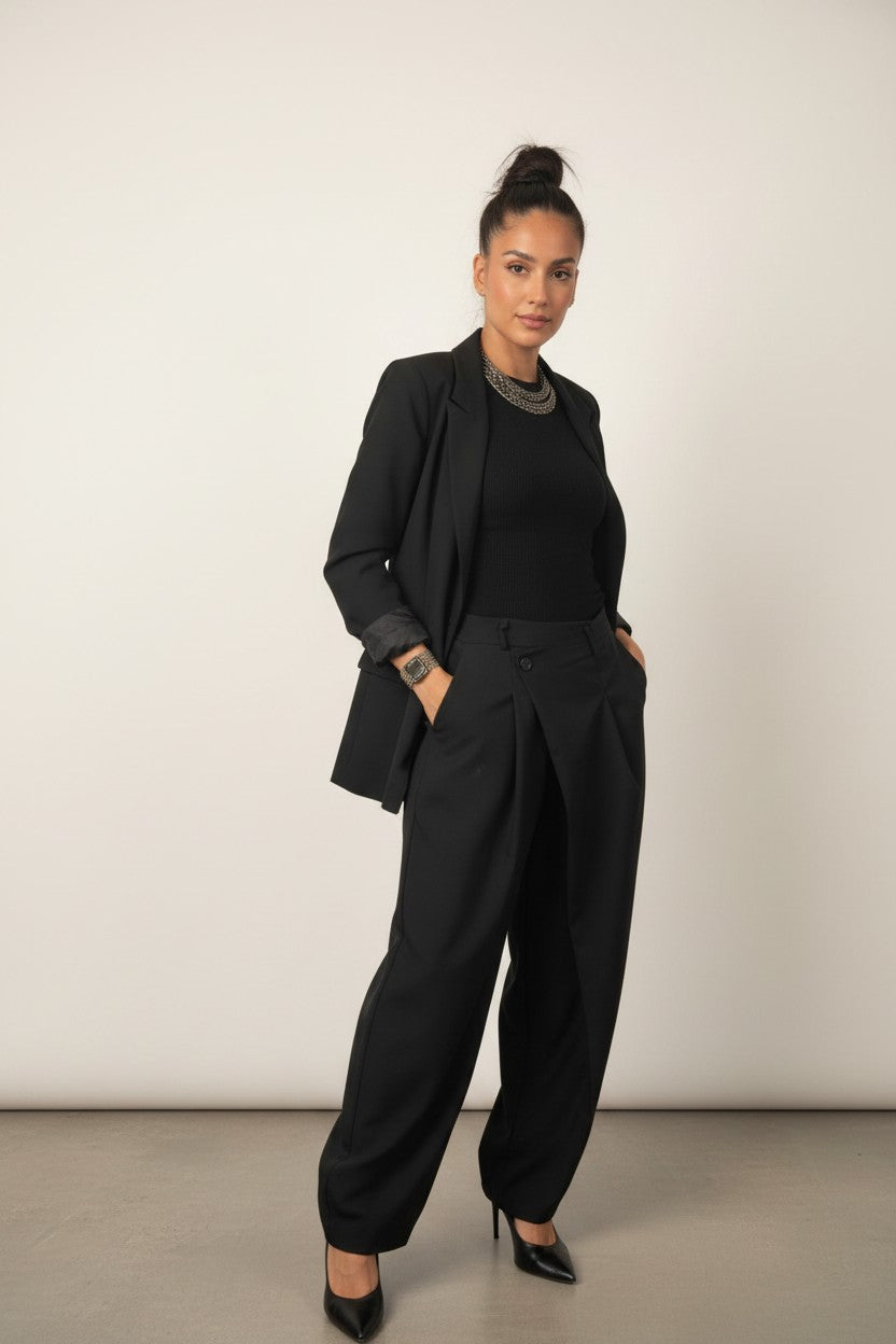 Femme portant le pantalon large à ceinture croisée noir, plis marqués et jambe ample