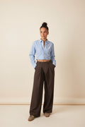 Femme portant le pantalon large à ceinture croisée marron, plis marqués et jambe ample